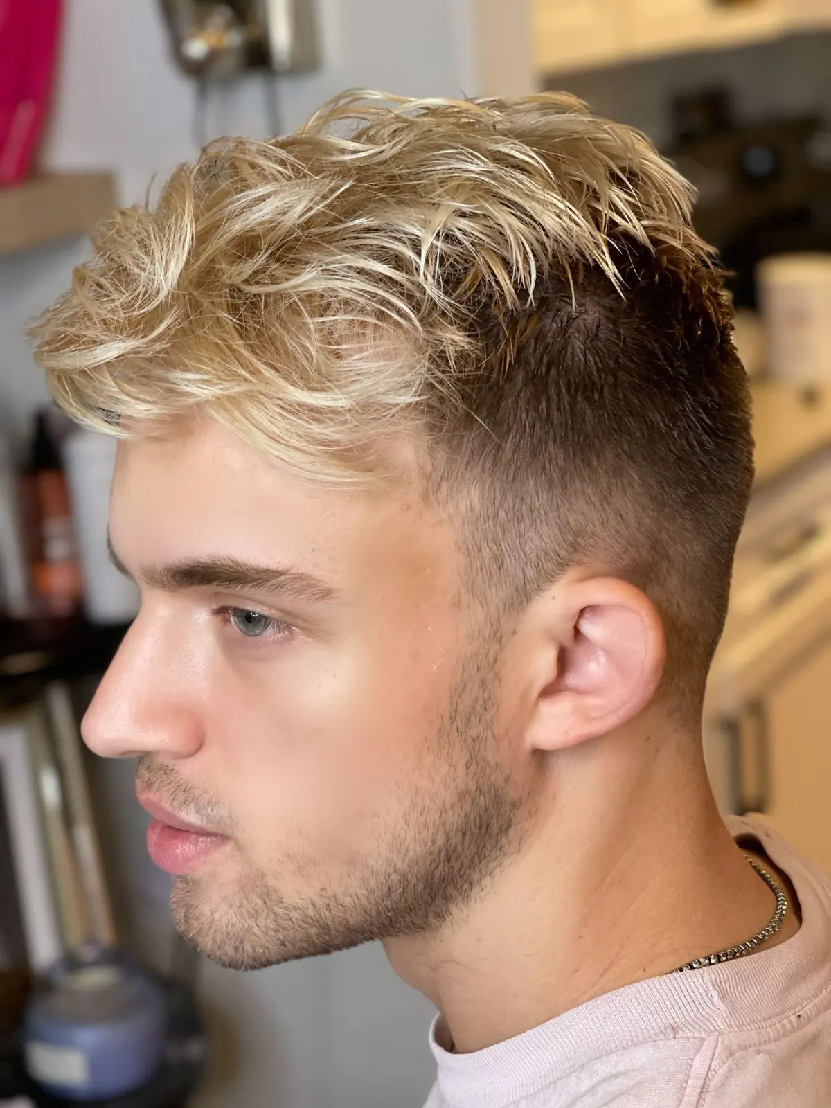 Men's textured blonde haircut and style in Austin